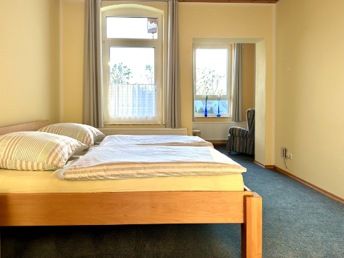 Doppelzimmer 2 mit Doppelbett und Sessel – Ferienwohnung 1 Rinteln