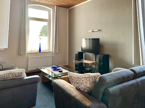 Wohnzimmer mit Sofas und Smart-TV – Ferienwohnung 1 Rinteln